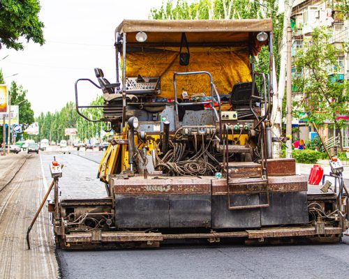 Paver on the road, road repair on the street in the city